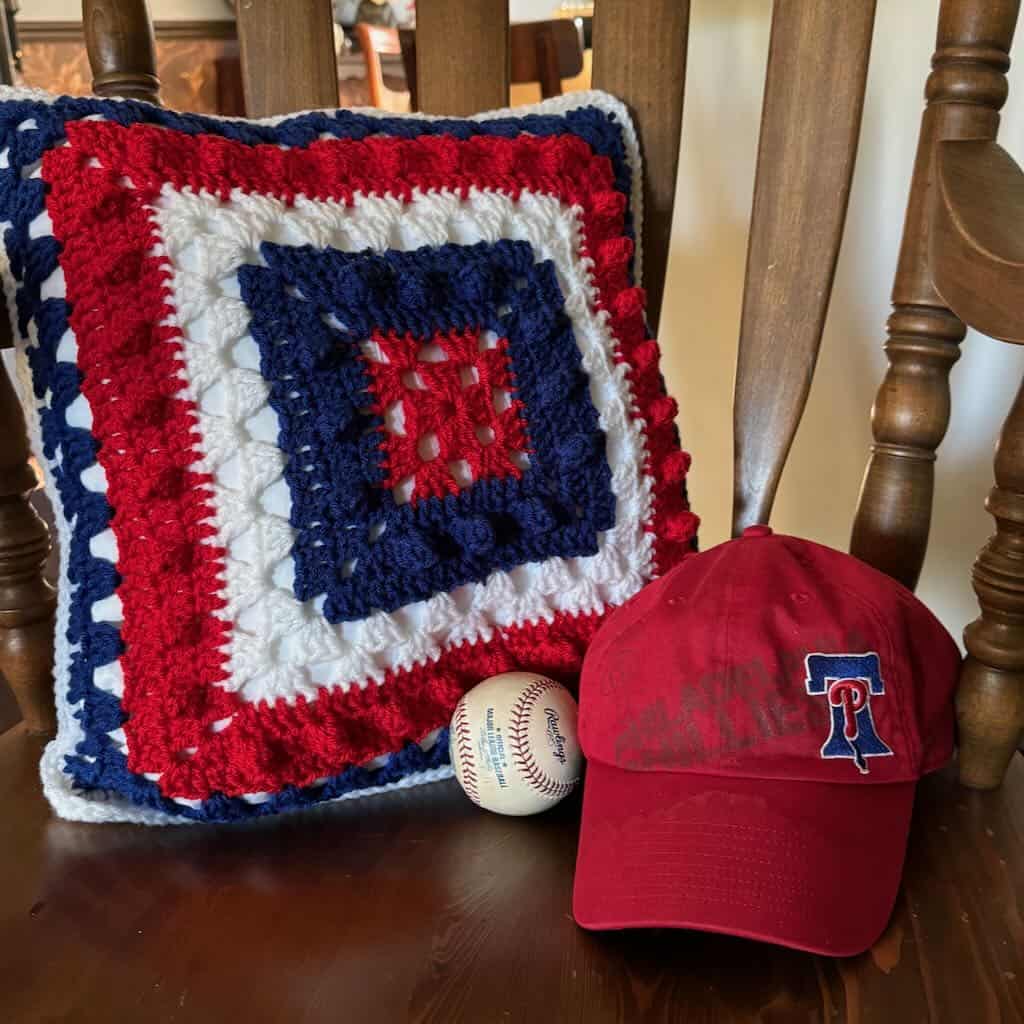 A photo of the I Love Baseball Pillow with a baseball and Phillies cap