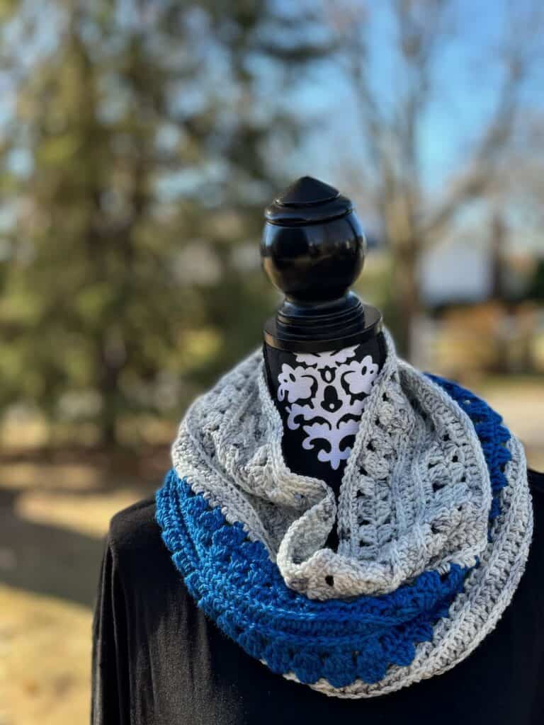 Photo of the Aria granny stitch cowl with trees in the background